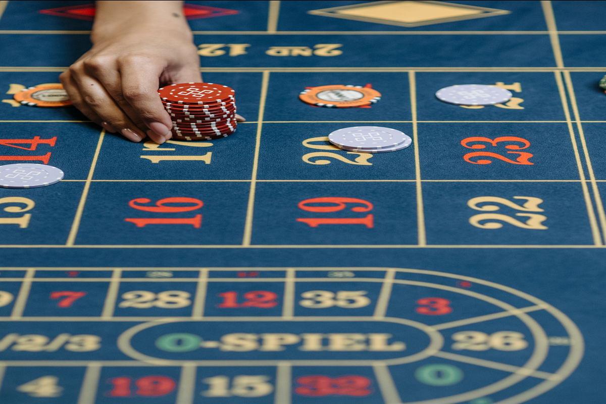 Tangan menempatkan chip di area taruhan pada meja